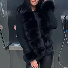 Person wearing a black fur coat standing next to a vehicle charging station.