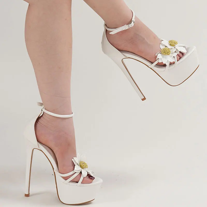 White high-heeled shoes with floral details on a light background