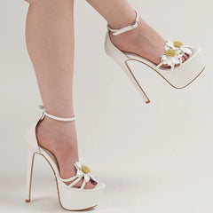 White high-heeled shoes with floral details on a light background