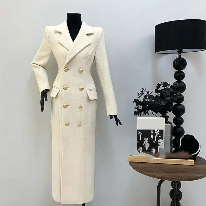 White coat on a mannequin next to a side table with decor items