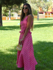 Woman in a pink floral dress standing in a park