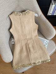 Beige dress with gold sequin details on a chair