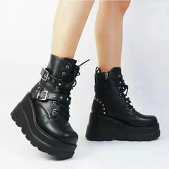 Black platform boots with buckles on a white background