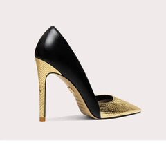 Black and gold high-heeled shoe on a light gray background