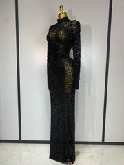 Black beaded evening gown on a mannequin against a white wall.