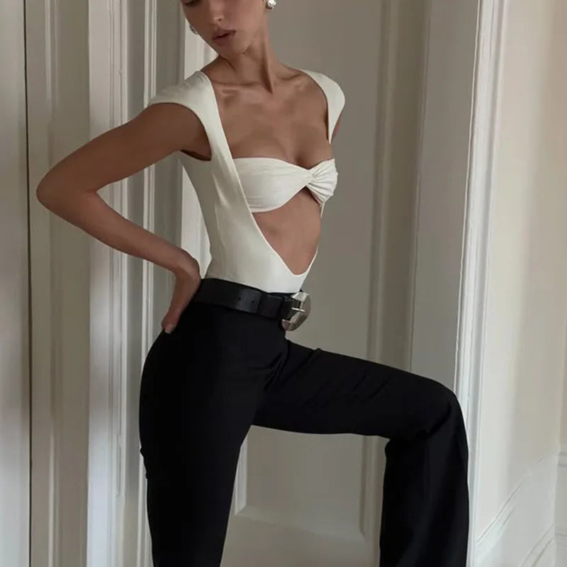 Model posing in a white twisted bustier cutout bodysuit