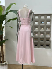 Pink dress on a mannequin against a geometric wall pattern