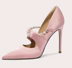 Pink high-heeled shoe with pearl embellishments on a light gray background