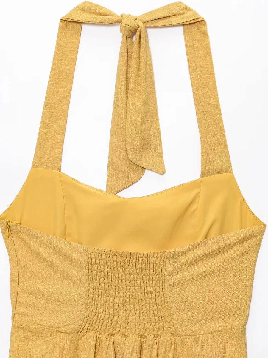 Yellow dress with smocked bodice and tied straps on a white background