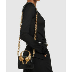 Side view of a black crocodile effect top handle bag with gold tiger sculptures and chain strap
