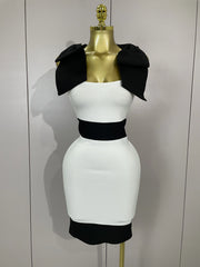 White dress with black accents on a mannequin against a plain background