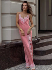 Woman wearing a pink lace nightgown standing on steps.