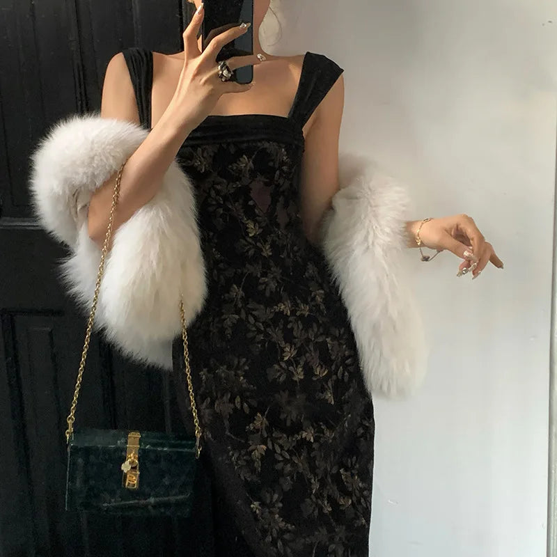 Person wearing a black floral dress with a white fur stole and green handbag.