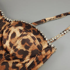 Leopard print bikini top with rhinestone details on a gray background