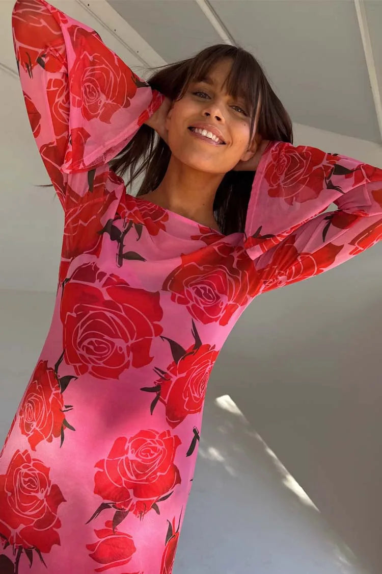Person wearing a pink outfit with red rose patterns against a neutral background