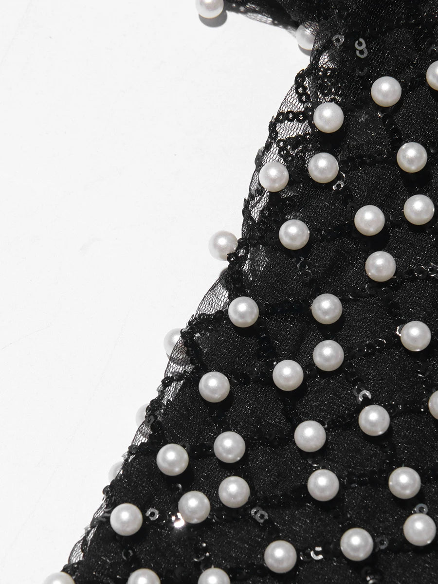 Black tulle fabric with white pearls on a white background