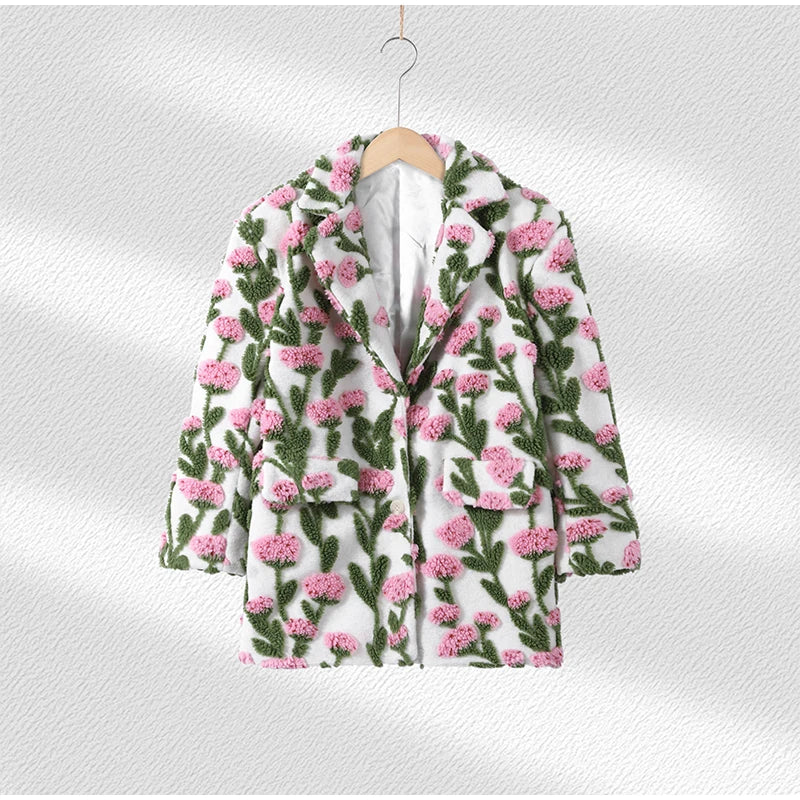Floral patterned coat on a hanger against a light background