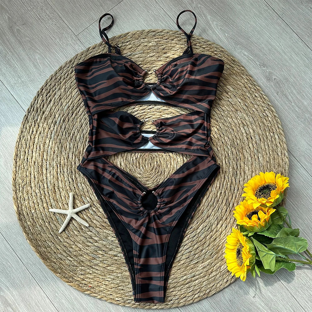 Zebra print cutout one-piece swimsuit styled with beach accessories.