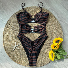 Zebra print cutout one-piece swimsuit styled with beach accessories.