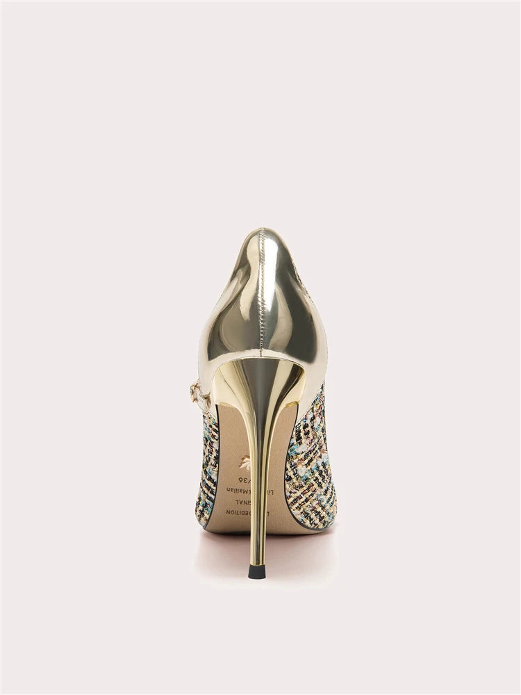 Gold high-heeled shoe with embellishments on a light gray background