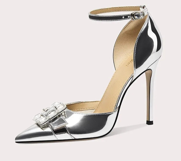 Silver high-heeled shoe with a decorative buckle on a white background