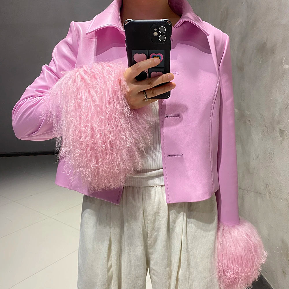 Person wearing a pink jacket with fluffy sleeves taking a mirror selfie.