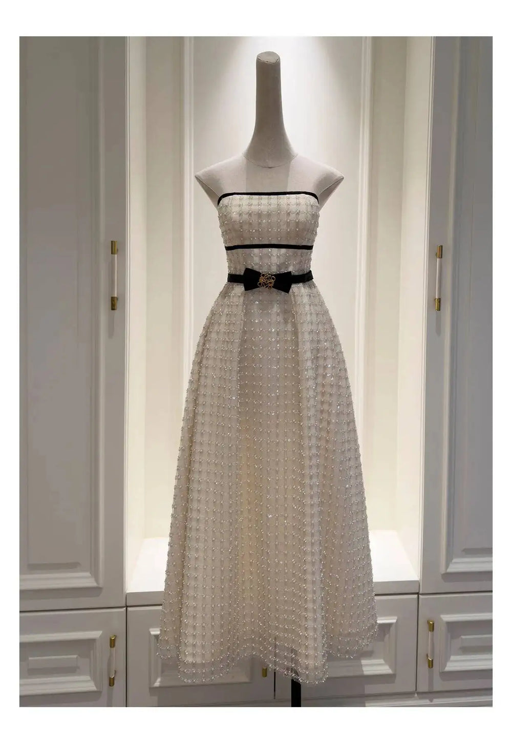 Strapless sequin midi dress on a mannequin in a wardrobe setting