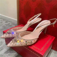 Pair of high-heeled shoes with rhinestone details on a red box.