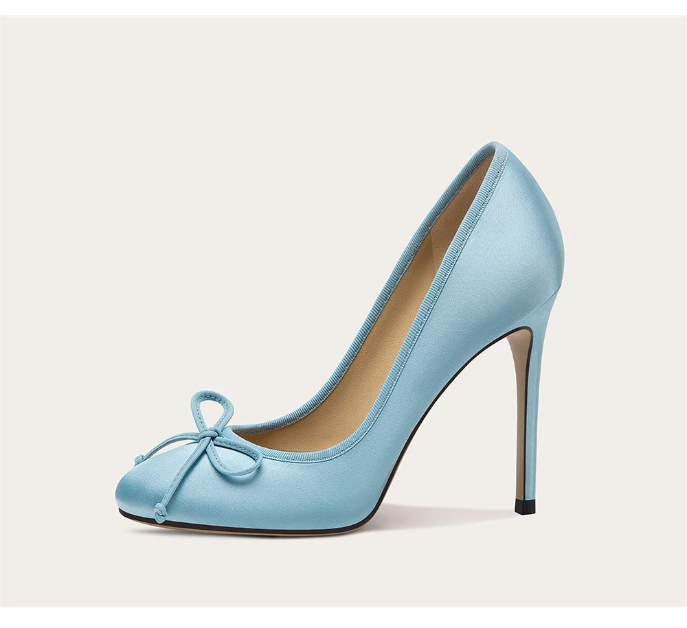 Light blue high-heeled shoe with a bow on a beige background