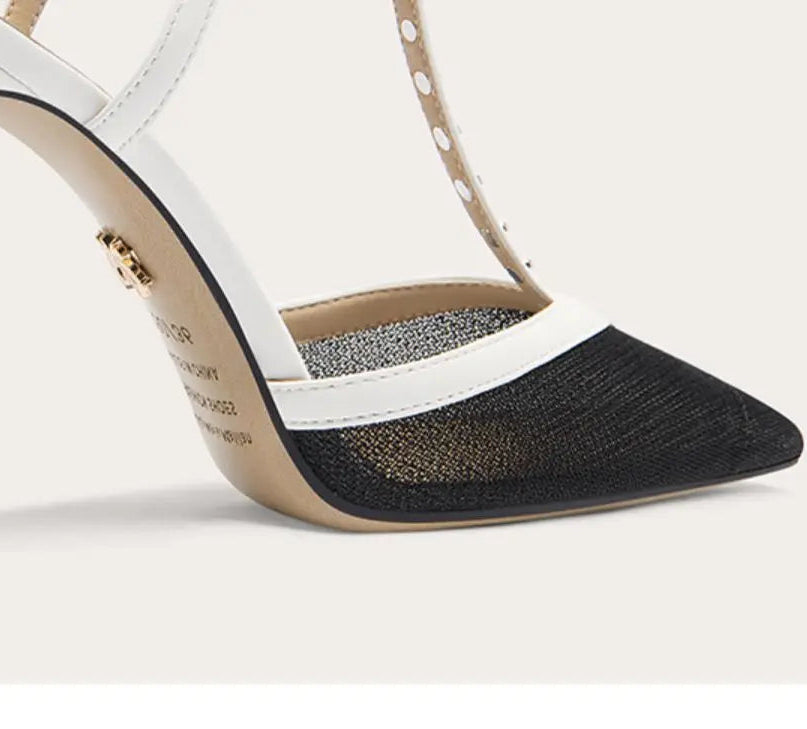 White high-heeled shoe with black mesh side on a light gray background