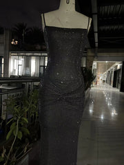 Black sequin dress on a mannequin in an indoor setting with plants and furniture.