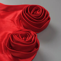 Two red fabric roses on a gray background