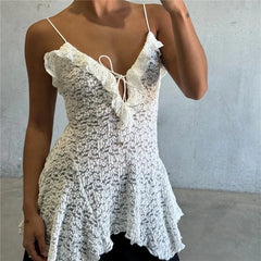Woman wearing a white lace dress against a plain background