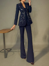 Woman wearing a black beaded blazer suit set indoors