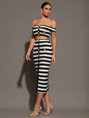 Woman wearing a black and white striped outfit against a gray background