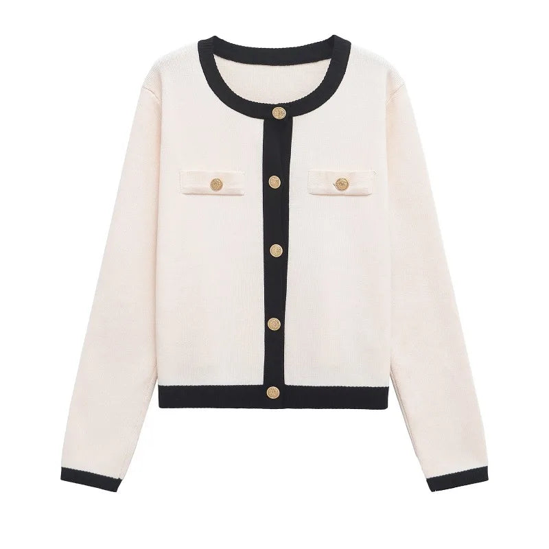 White cardigan with black trim and gold buttons on a white background