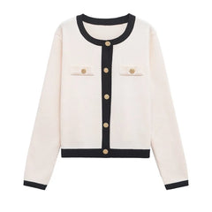 White cardigan with black trim and gold buttons on a white background