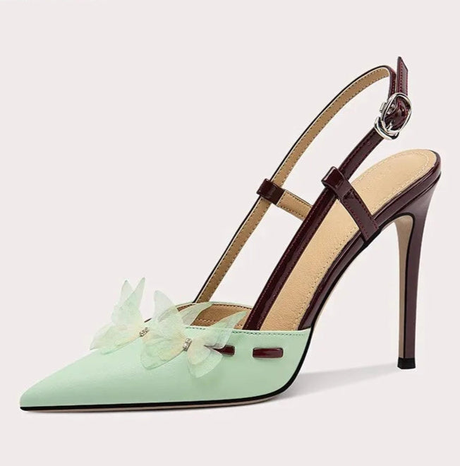 Mint green high-heeled shoe with brown strap on a light gray background