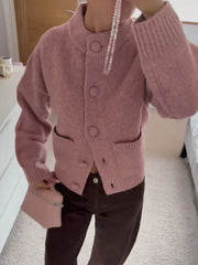 Person wearing a pink cardigan in an indoor setting