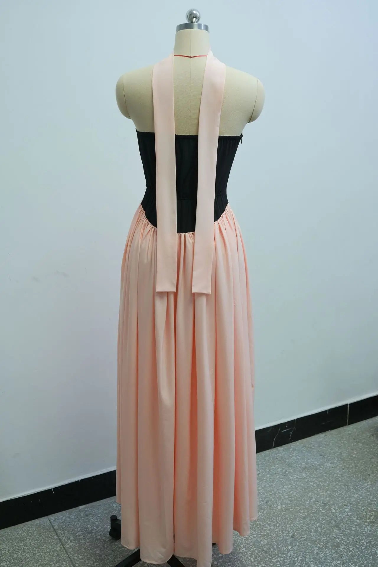 Mannequin wearing a black top and peach skirt with a white background