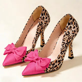 Leopard print pointed toe pumps with a pink bow accent.