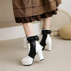 Black and white platform boots with ruffles worn by a person in a brown skirt.