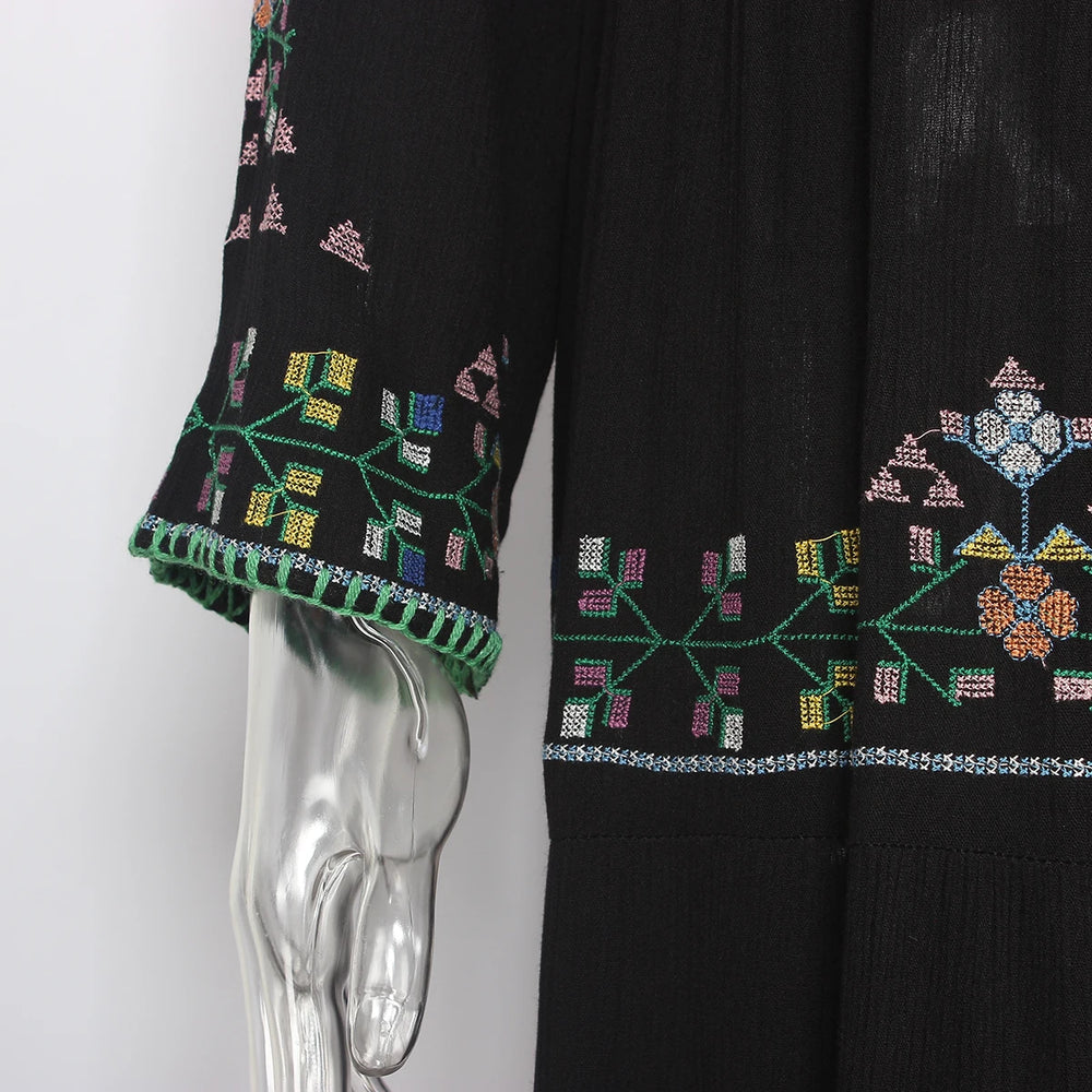 Black garment with colourful embroidery on a mannequin
