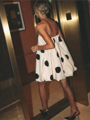 Woman in a polka dot dress standing in an elevator