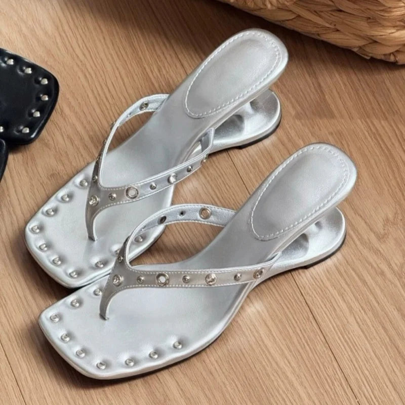 Close-up of silver studded square toe flip flop sandals