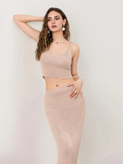 Woman wearing a beige knit top and skirt against a plain background