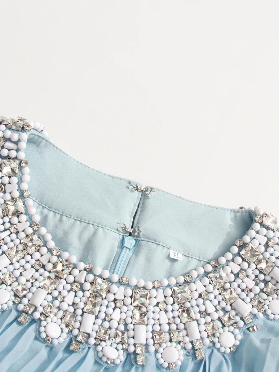 Light blue garment with white beaded collar on a white background