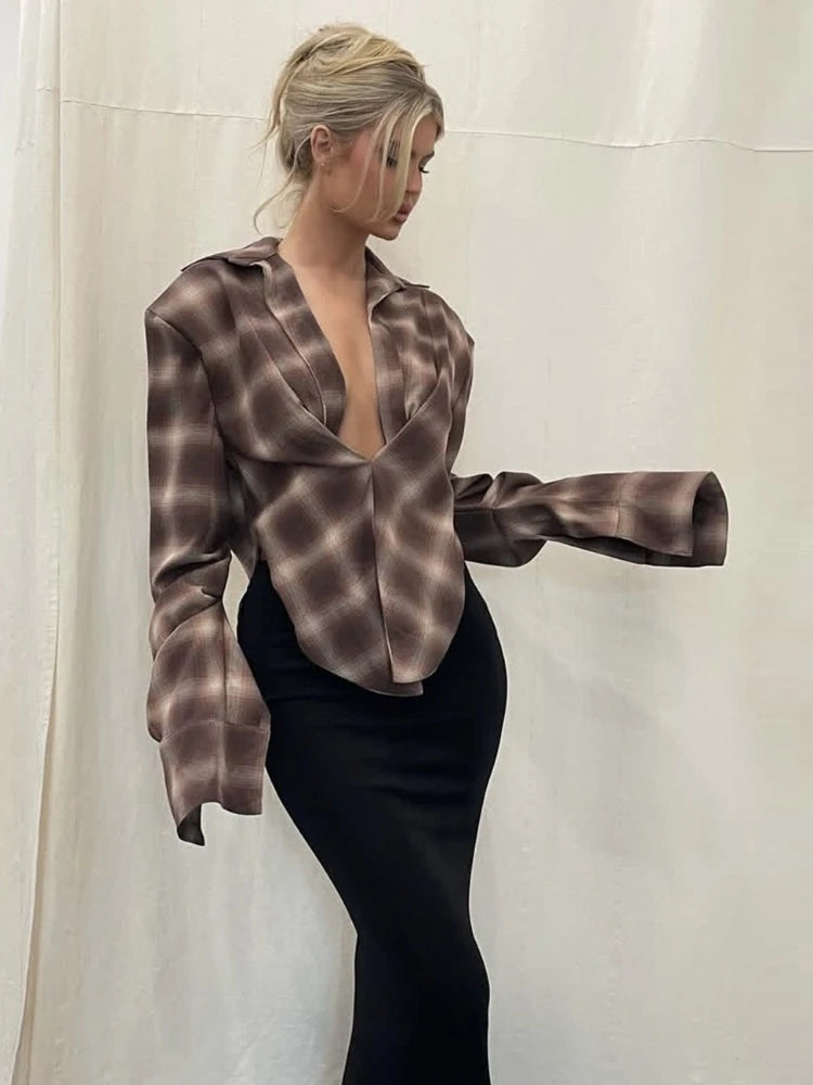 Woman wearing a draped plaid crop shirt with a deep open neckline