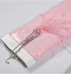 Close-up of a pink fabric with white trim and decorative elements on a light gray background