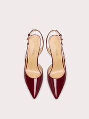 Pair of red high-heeled shoes on a light beige background